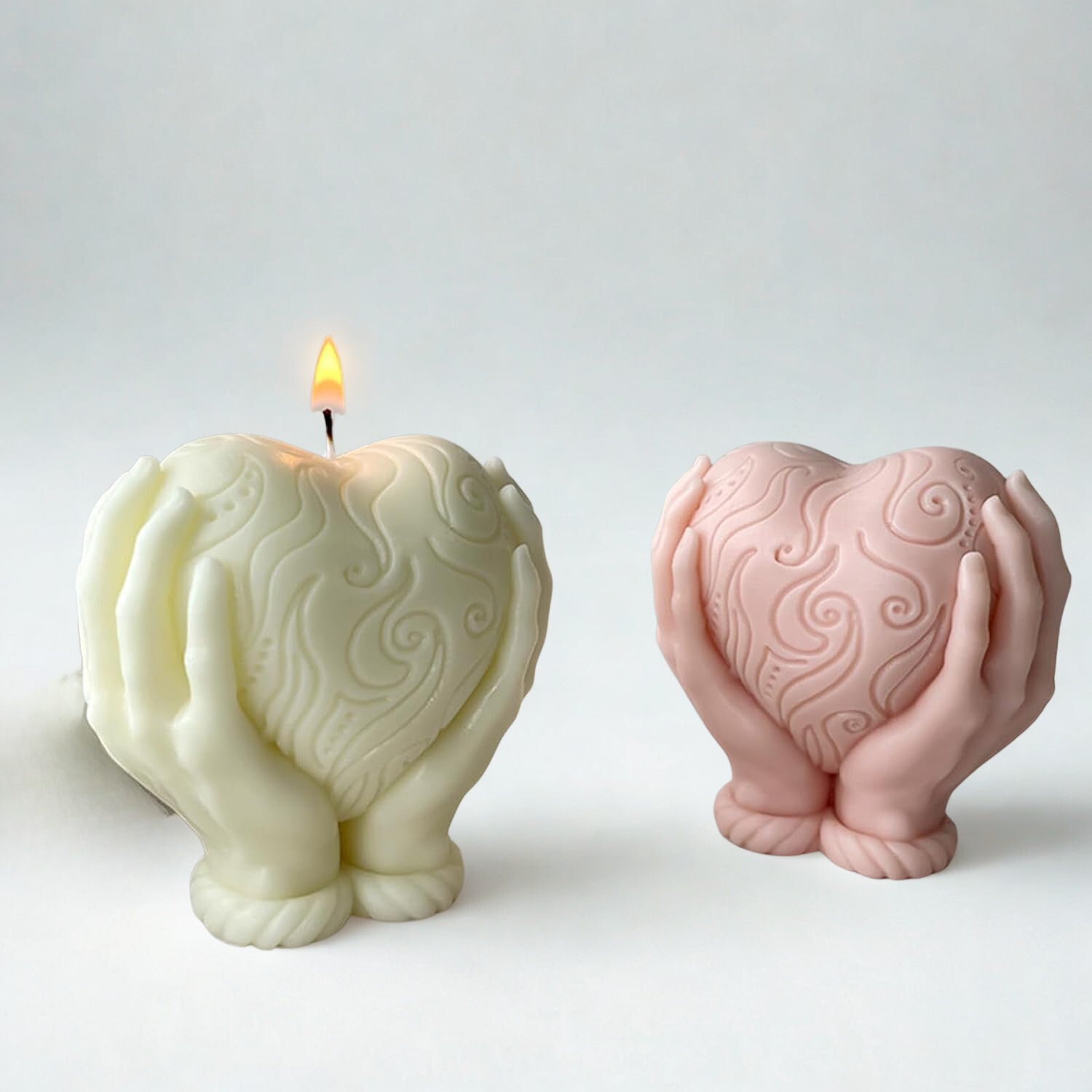 Heart-shaped candle with flame and matching pink heart-shaped holder on a white background