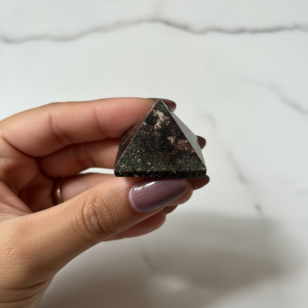 Garnet Pyramid held in hand - editorial product photography