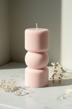 Pastel blush pink sculptural three-tier ribbed pillar candle on white marble - Just Natural Purity