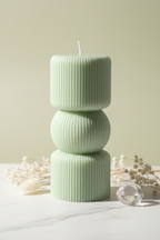 Pastel sage green sculptural three-tier ribbed pillar candle on white marble - Just Natural Purity