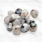 Rainbow Moonstone Tumbled Stones with white milky and blue flash on marble