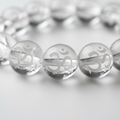 Clear Quartz AUM bracelet ultra close-up showing OM symbol engraved on every crystal bead - Just Natural Purity