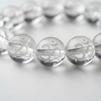 Clear Quartz AUM bracelet ultra close-up showing OM symbol engraved on every crystal bead - Just Natural Purity