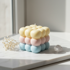 Triple cloud bubble cube candle with pastel yellow pink and sky blue layers on white marble - Just Natural Purity