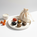 Energy & Vitality Crystal Set - Red Carnelian, Tiger Eye, Black Obsidian and Bronzite tumbles on white plate with cotton potli