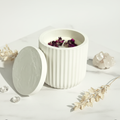 Rose petal jar candle styled flat lay on white marble with crystals and botanicals
