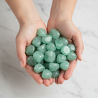 Light green Aventurine tumble stones bunch cupped in elegant hands close-up