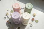 Sculptural three-tier ribbed pillar candles in pastel colours group shot on white marble - Just Natural Purity