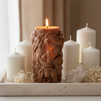 Lit goddess sculptural pillar candle on travertine tray with white pillar candles, dried flowers and crystal cluster home decor