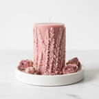 Blush pink botanical leaf relief pillar candle on marble surface with dried pink roses luxury home decor