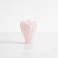 Rose Quartz 1 inch pocket angel figurine — hand-carved crystal angel on white background