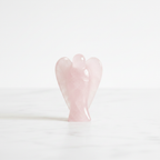 Rose Quartz 1 inch pocket angel figurine — hand-carved crystal angel on white background