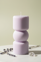 Pastel lavender sculptural three-tier ribbed pillar candle on white marble - Just Natural Purity